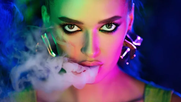 Fashion girl smoking e-cigarette in neon lights — Stock Photo, Image