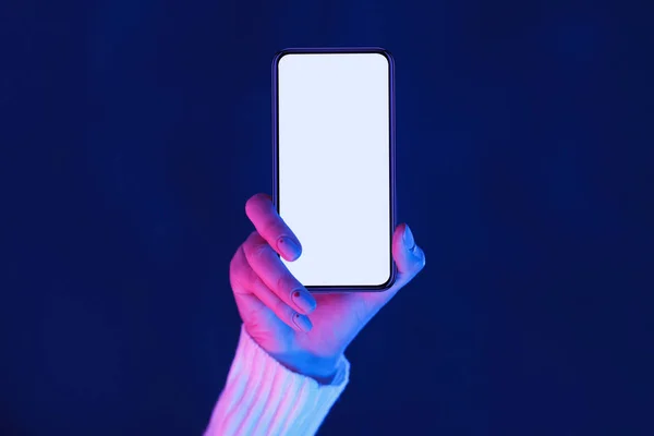 Mujeresmano que muestra la pantalla del teléfono inteligente en luces de neón —  Fotos de Stock