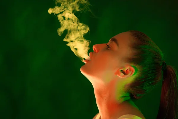 Chica Fumadora. Mujer en luces verdes con humo blanco — Foto de Stock