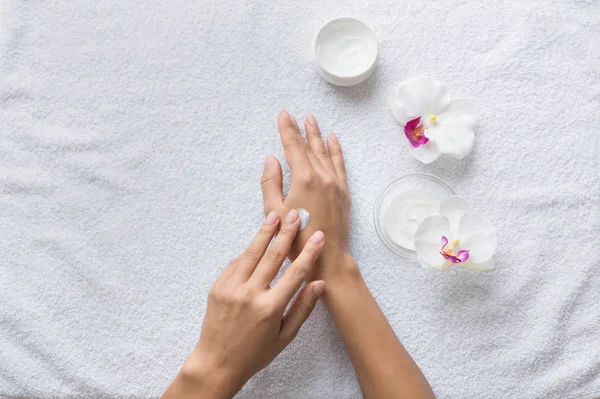 Concepto nutritivo de la piel. Mujer poniendo crema en sus manos — Foto de Stock