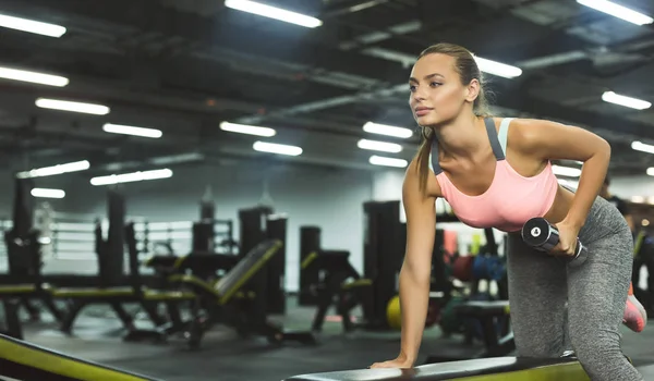 Sportowa dziewczyna pracuje z ciężarkami w klubie sportowym — Zdjęcie stockowe