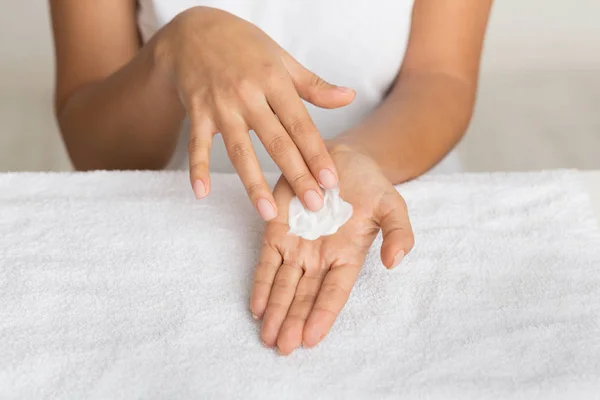 Nutrição da pele. Menina espalhando creme nutritivo na palma da mão — Fotografia de Stock