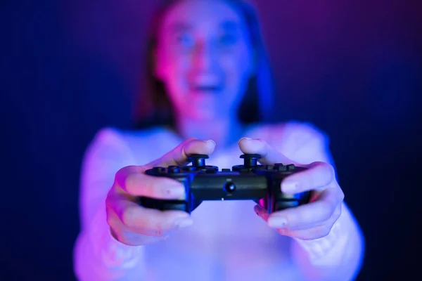 Женщина, играющая в видеоигры ночью, нажимающая на кнопки, крупный план — стоковое фото