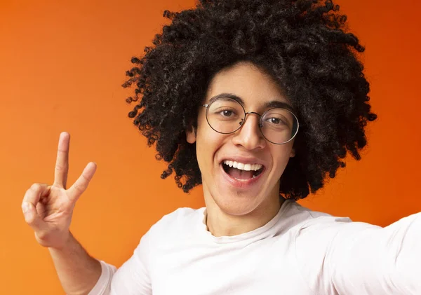 Cheerful african american guy gesturing v sign on camera