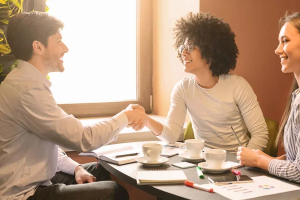 Giovani che si stringono la mano, raggiunto un accordo durante il pranzo di lavoro — Foto Stock