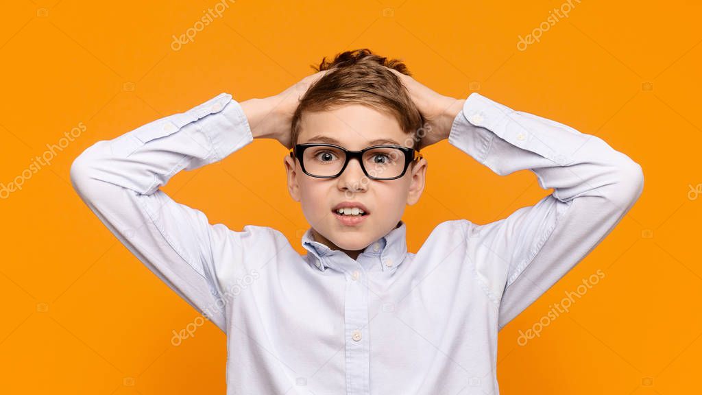 Shocked little boy having troubled, touching his hair