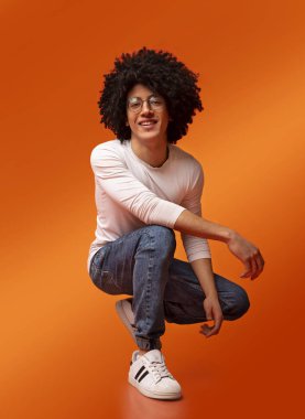 Genç siyahi adam yere kapanıp gülümsüyor.