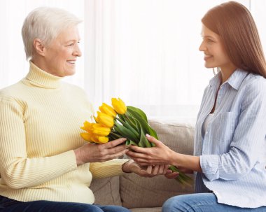 Anneler gününü kutluyoruz. Kızı anneye buket veriyor