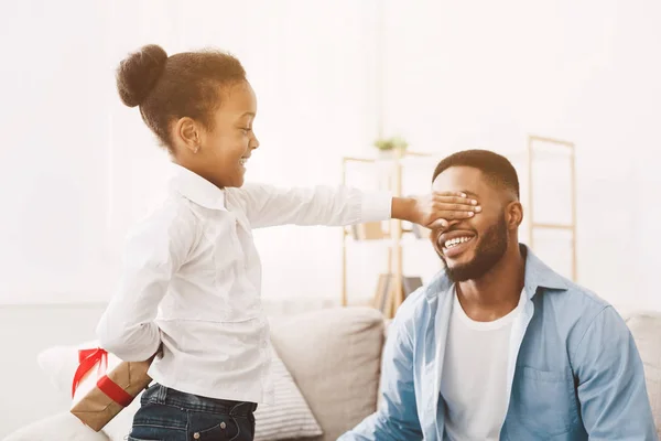 Kleines Mädchen macht Papa ein Geschenk und schließt die Augen — Stockfoto