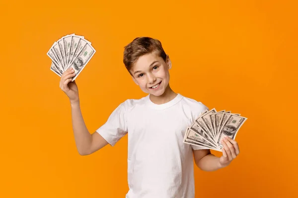 Schattige tiener jongen houden fans van geld en glimlachend — Stockfoto