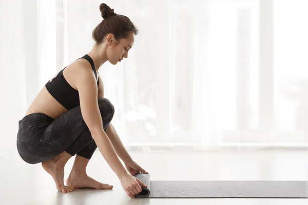 Tapis à roulettes pour fille après le cours de yoga, vue latérale — Photo