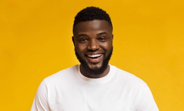 Sevimli kaygısız siyah adam turuncu arka plan üzerinde gülüyor