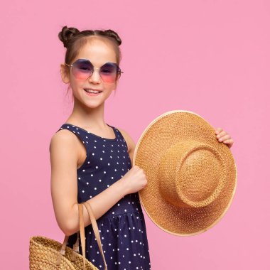 Pembe üzerinde yaz şapkası tutan pretty küçük kız
