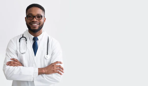 Feliz Doctor en uniforme blanco contra fondo de luz —  Fotos de Stock