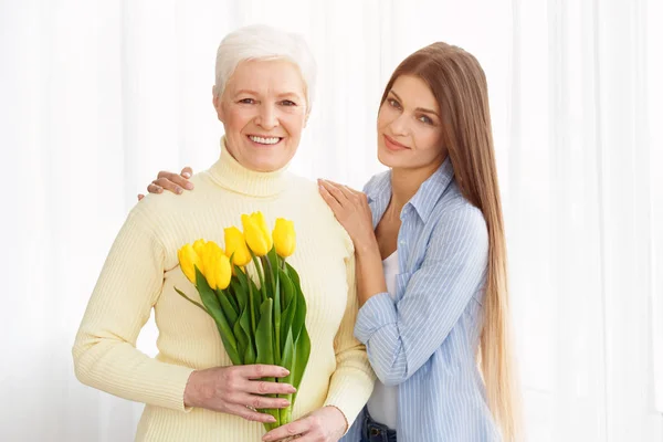 Hija dando a su madre ramo de tulipanes —  Fotos de Stock