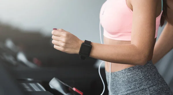 Treino no ginásio. Mulher usando smartwatch e ouvir música — Fotografia de Stock