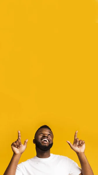 Счастливый возбужденный африканский американец, указывающий на пустое место — стоковое фото