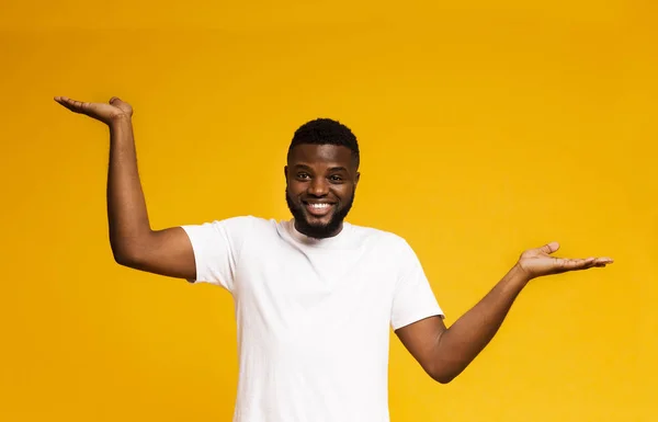 Позитивний афроамериканець людина робить ваги з його порожніми руками — стокове фото