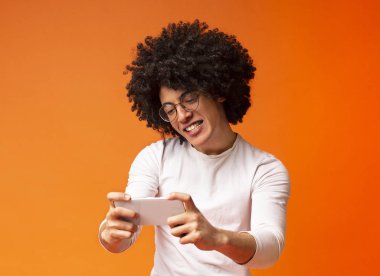 Mobil uygulama kullanarak video oyunu oynayan genç bir adam.