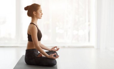 Yoga yapan kadın, Ardha Padmasana egzersizi yapan.
