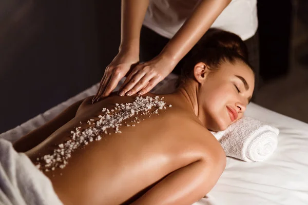 Mujer disfrutando del masaje con exfoliante de sal, relajarse en el spa de salud — Foto de Stock