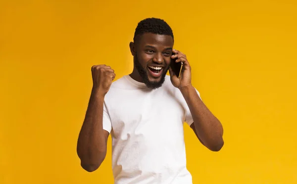 Afro-amerikai ember beszél mobiltelefonon, és mosolyogva — Stock Fotó