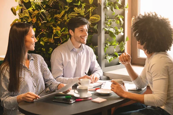 Gruppo di giovani imprenditori con briefing in caffetteria — Foto Stock