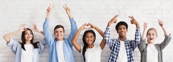 Studenten gebaren met handen over witte muur — Stockfoto