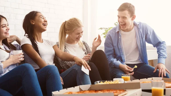 Mutlu öğrenciler pizza yiyip evde gülüyorlar. — Stok fotoğraf