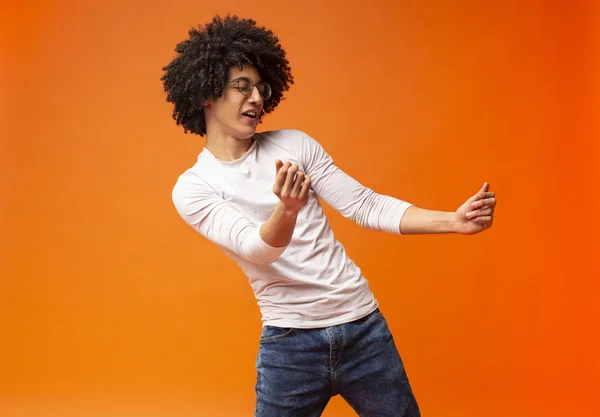 Flexibele duizendjarige zwarte kerel dansen op oranje achtergrond — Stockfoto