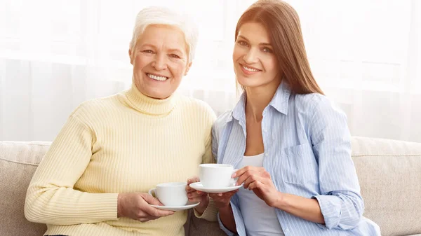 Godetevi la colazione con la mamma. Madre e figlia in possesso di tazze — Foto Stock