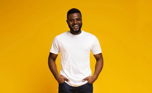 Positive african american man laughing with hands in pockets — Stock Photo, Image