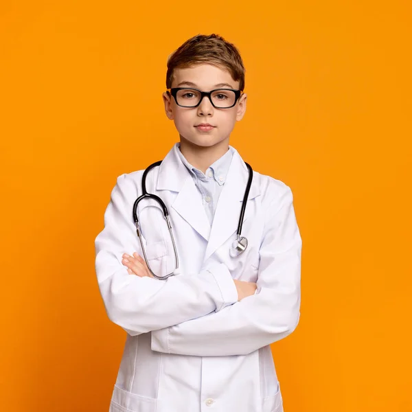 Confident teen boy in doctor uniform posing with arms folded — Stock Photo, Image