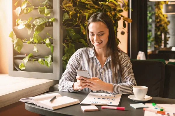 Feliz millennial mujer charlando en el teléfono celular en la cafetería —  Fotos de Stock