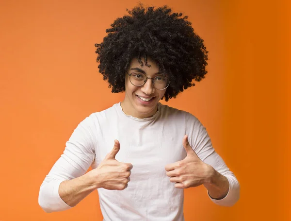 Дружелюбный черный мужчина показывает пальцами вверх обеими руками — стоковое фото