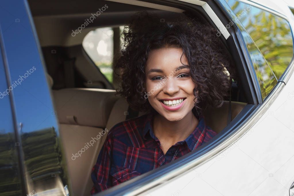Smiling afro woman in car