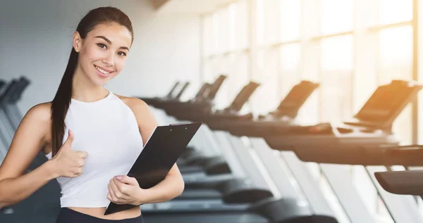 Instrutor de fitness. Mulher com área de transferência mostrando polegar para cima — Fotografia de Stock