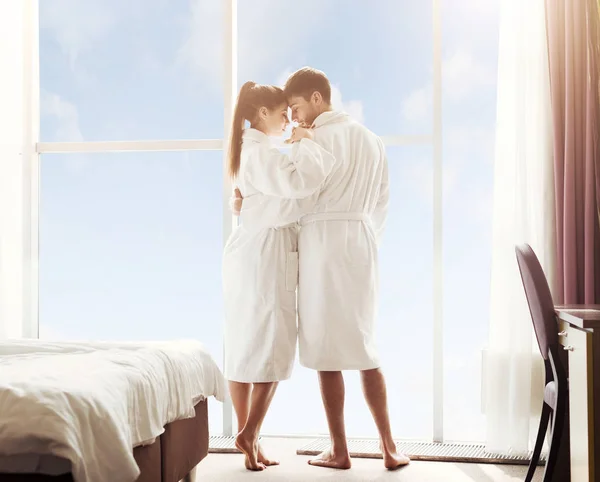Тысячелетняя пара путешествует вместе, обнимаясь в гостиничном номере — стоковое фото