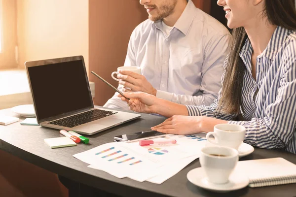 Compañeros discutiendo estrategia, analizando estadísticas en laptop — Foto de Stock