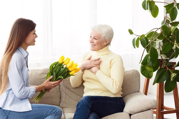 Feliz día de las madres. Hija dando ramo a mamá —  Fotos de Stock