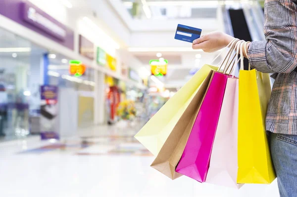 Mujer que lleva bolsas de compras y tarjeta de crédito — Foto de Stock