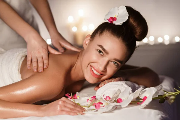 Relajante en el salón de spa. Mujer disfrutando de masaje de espalda —  Fotos de Stock