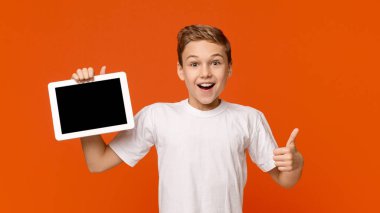 Boş dijital tablet ekranı gösteren genç çocuk