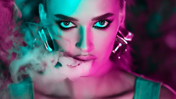 Smoking E-Cigarette. Woman in green and pink neon lights — Stock Photo, Image