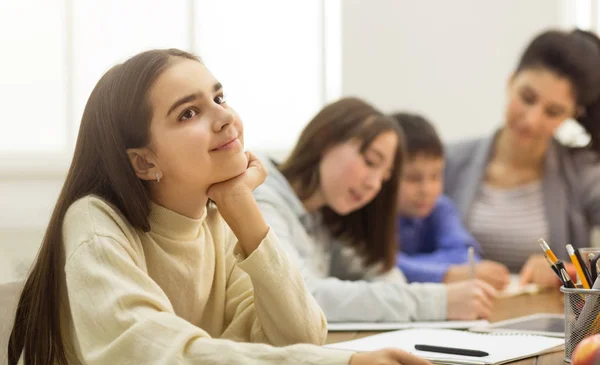 Schulmädchen träumt, sitzt beim Unterricht im Klassenzimmer — Stockfoto