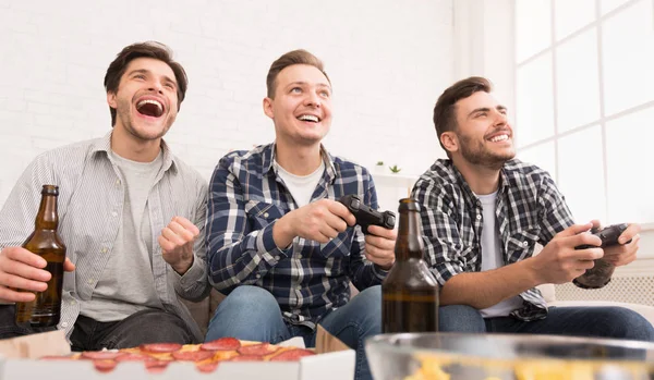 Junggesellenleben. Kumpels spielen Videospiele mit Bier und Pizza — Stockfoto