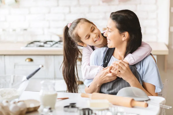 Hija cariñosa abrazando a su madre en la cocina . —  Fotos de Stock