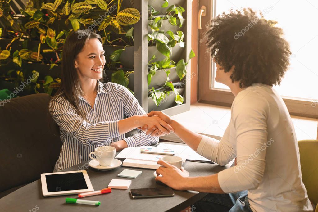 Friendly business people handshaking during business lunch