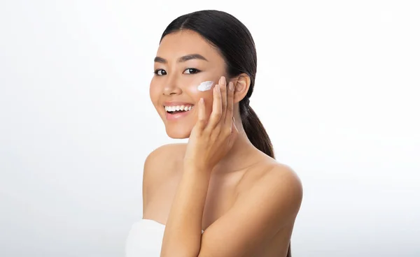 美容理念。亚洲 妇女 应用 保湿剂 在 脸上 — 图库照片