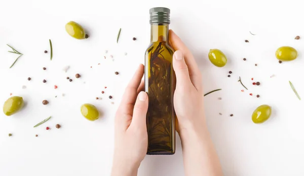 Botella con aceite de oliva en manos de mujer — Foto de Stock